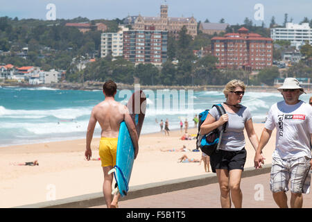 Mâle adulte surfer carrying surfboard on Manly Beach Sydney, Australie Banque D'Images