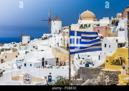 Ciel bleu et d'un drapeau près de village blanc traditionnel sur l'île de Santorin, Grèce Banque D'Images