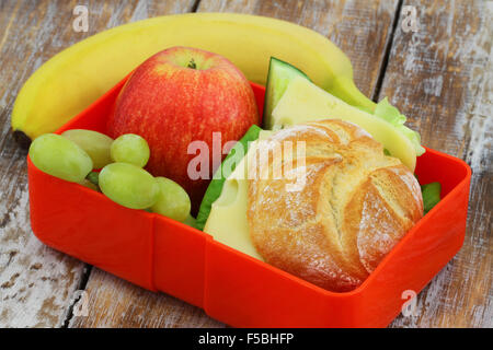 Déjeuner à l'école fort contenant du fromage roll, apple, raisins et bananes Banque D'Images