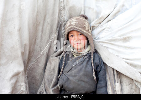 Un mignon petit garçon nomade tibétain scrutant de sa tente à l'hiver pâturages de Puga Banque D'Images