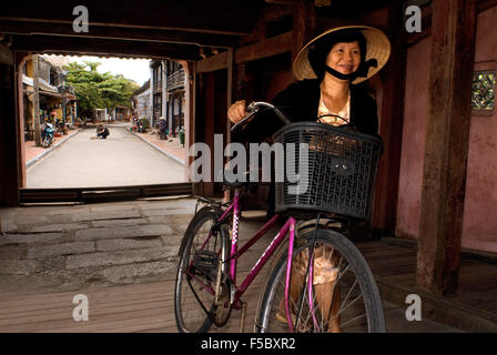 Vieille Femme dans un vélo traversant le pont couvert japonais de Hoi An, classé au Patrimoine Mondial de l'UNESCO, le Vietnam, l'Indochine, au sud-est Banque D'Images