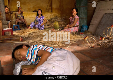 Enfant endormi à l'intérieur d'une des lanternes en soie fabriquées store, Hoi An, Vietnam. à Hoi An, Vieille Ville, Vietnam, Province de Quang Nam, lis Banque D'Images