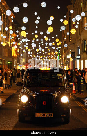 Londres, Royaume-Uni. 1er novembre 2015. London taxi noir à l'allumage de Oxford Street et des lumières de Noël décorations de Noël à Londres, mais certaines n'a pas réussi à mettre en marche immédiatement et n'est entré sur plus tard Crédit : Paul Brown/Alamy Live News Banque D'Images