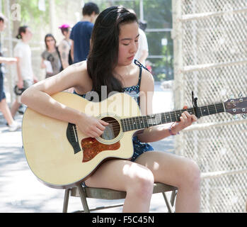 Teenage Girl Playing Guitar in Park Banque D'Images