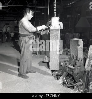 Historique des années 1950, l'homme travaillant dans une fonderie de fonte, Londres, Angleterre. Banque D'Images