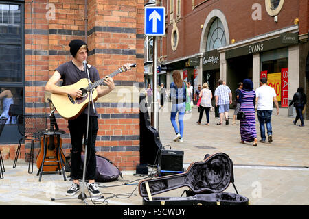 LEEDS, Yorkshire, UK. Le 12 juillet 2015. Un seul musicien ambulant joue de la guitare et chante pour le dimanche à la Leeds shoppers dans le Yorkshire, UK. Banque D'Images