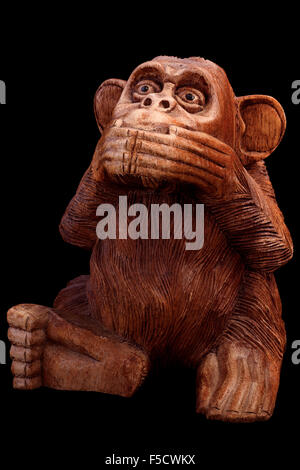 La statuette du singe. Figurine en bois sur un fond noir. Banque D'Images