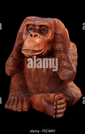 La statuette du singe. Figurine en bois sur un fond noir. Banque D'Images