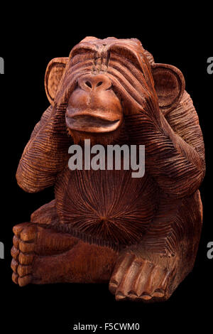 La statuette du singe. Figurine en bois sur un fond noir. Banque D'Images