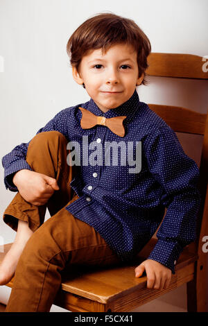 Peu cute boy dans bowtie smiling, making funny faces Banque D'Images