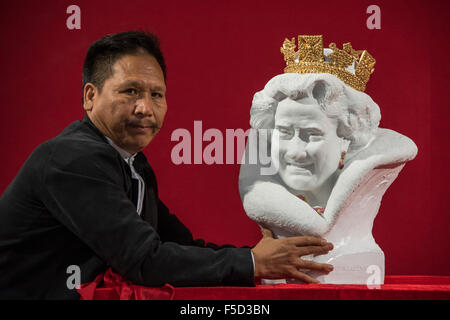 Londres, Royaume-Uni. 09Th Nov, 2015. Chen Dapeng dévoile un nouveau buste de Sa Majesté la Reine Elizabeth II, qu'il a exécuté pour célébrer l'année 2015 UK-Chine d'échange culturel (c'est sur un stand avec ses millions de livres d'autres œuvres). Olympia hiver Art & Antiques Fair- dans sa 25e année, le salon accueillera 22 000 visiteurs qui viennent voir plus de 30 000 pièces pour la vente de la 120 concessionnaires triés sur le frpom d'une valeur de £100-£1m. La foire est 2-8 novembre 2015, avec l'ouverture de la réception d'aperçu le 2 novembre à 5h00.. Crédit : Guy Bell/Alamy Live News Banque D'Images