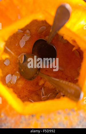 Les enfants de mêmes parents de garçons blonds hollowing out halloween citrouille à l'extérieur dans le jardin, assis sur la pelouse d'herbe d'automne, Banque D'Images