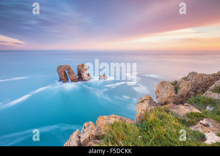 La célèbre formation rocheuse connue comme 'La Puerta del Mar' ('La porte de la mer") par le lever du soleil. Costa Quebrada, Liencres, Cantabria, Banque D'Images