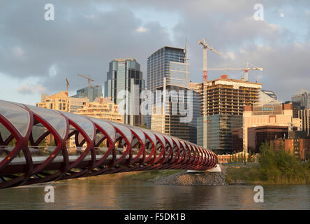 Les grues de construction et de bureau en construction dans le centre-ville de Calgary, Peace Bridge en premier plan Banque D'Images