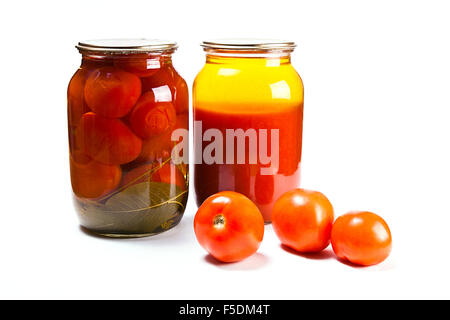 Les tomates rouges frais et en conserve dans un bocal en verre isolé sur fond blanc. Jus de tomates maison conserve dans un bocal en verre. Ca savoureux Banque D'Images