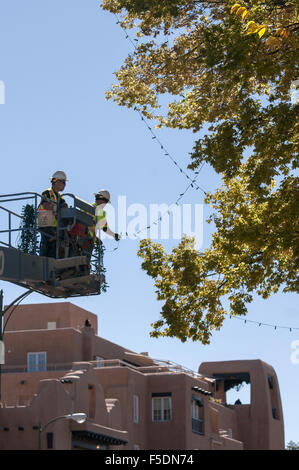 Usa. 2e Nov, 2015. Randy Lopez, gauche et Porfirio Lovato, avec Ville de Santa Fe de la division des parcs, chaîne de Lumière de Noël sur les arbres autour de la Santa Fe Plaza lundi 2 novembre 2015. Les travailleurs ont la ville autour de 3 semaines pour s'allume et le prêt. La cérémonie d'allumage de la Plaza a lieu le vendredi après Thanksgiving le 27. © Eddie Moore/Albuquerque Journal/ZUMA/Alamy Fil Live News Banque D'Images