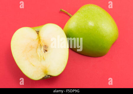 Les deux moitiés d'une pomme sur fond rouge. La saine alimentation abstract Banque D'Images