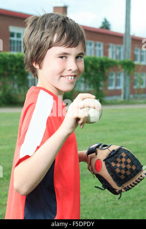 Portrait d'un jeune joueur de baseball dans un champ Banque D'Images