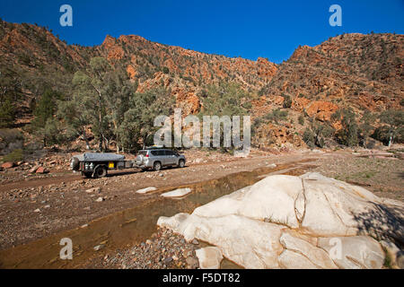 Quatre roues motrices le remorquage du véhicule camping-remorque sur route à travers des collines de rouge robuste de Flinders en Australie outback Banque D'Images