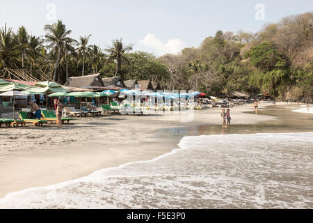 Parasols, chaises longues et à warungs, Pasir Putih ou plage de sable blanc, à Bali, Indonésie. Banque D'Images