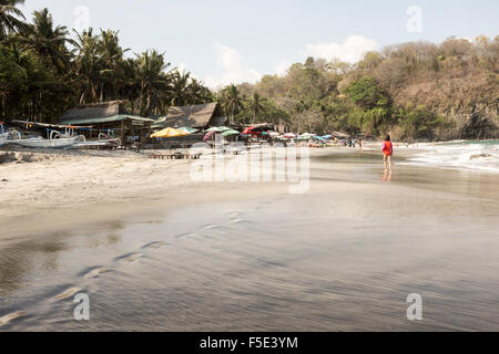 Parasols, chaises longues et à warungs, Pasir Putih ou plage de sable blanc, à Bali, Indonésie. Banque D'Images