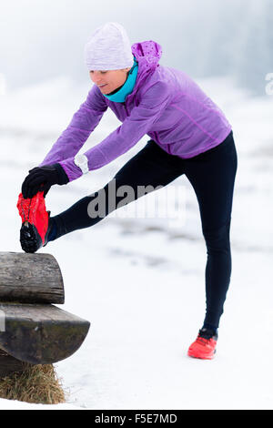 Sport, de la condition physique d'inspiration et de motivation. Jeune femme heureuse course cross-country en montagne sur la neige l'hiver, jour de l'exercice. Banque D'Images