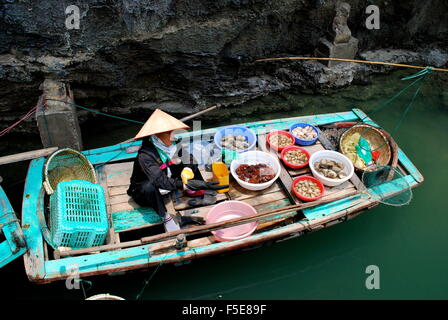 Vendeur de fruits femelle sur un bateau à la baie d'Ha Long, Vietnam Banque D'Images