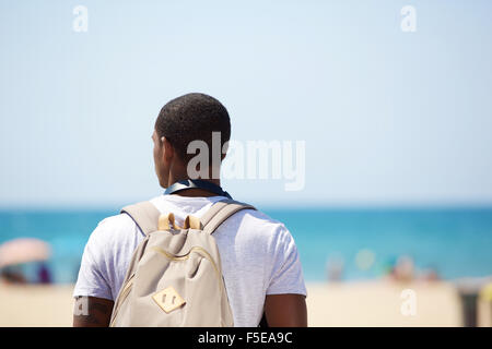 Portrait de derrière d'un homme debout sur la plage avec sac Banque D'Images