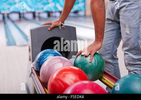 Jeune homme prendre bowling ball Banque D'Images