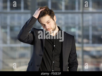 Close up portrait of a handsome male fashion model posing with hand in hair Banque D'Images