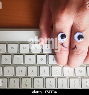 Google les yeux et sourire dessiné sur un côté, de taper au clavier Banque D'Images