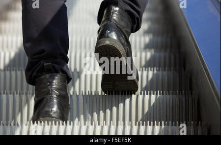 L'angle faible en marche pieds mâles démarre escalator Banque D'Images