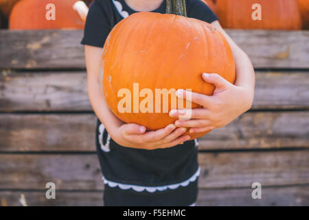 Close-up of a Girl holding large pumpkin Banque D'Images