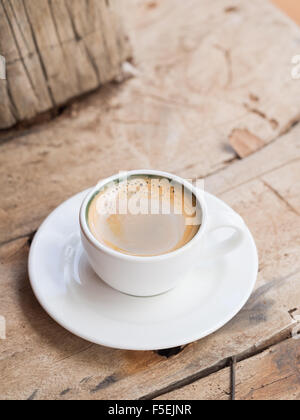Dans un double expresso tasse blanc placé sur une table en bois en dhow. Portrait, orientation verticale. Banque D'Images