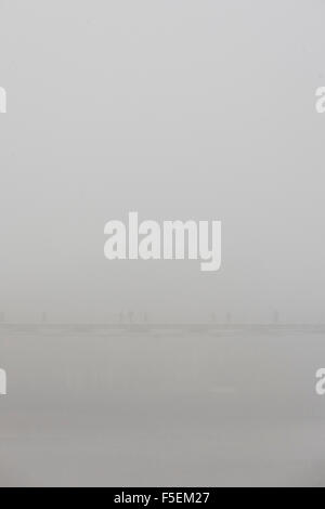 Brouillard matinal enveloppes piétons traversant la Tamise sur le pont du Millénaire. Banque D'Images