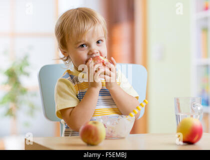 L'alimentation de l'enfant dans les jardins d'Apple au dîner à la maison Banque D'Images