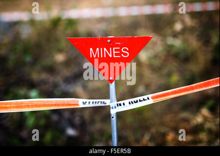 Triangulaires, rouge "ines" signe sur l'aide de ruban isolant mine field Banque D'Images