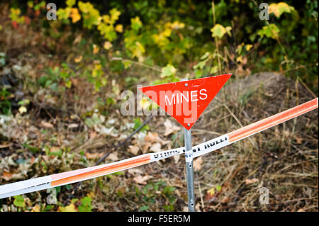 Triangulaires, rouge "ines" signe sur l'aide de ruban isolant mine field Banque D'Images