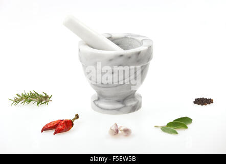 Un traditionnel en mortier et pilon avec diverses herbes et d'épices isolé sur fond blanc Banque D'Images