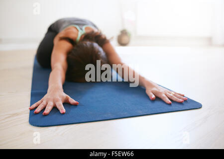 Woman doing stretching entraînement sur tapis de fitness. Mettre en place des femmes yoga sur tapis d'exercice à la salle de sport. Pose de l'enfant, Balasana. Banque D'Images