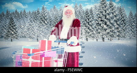 Image composite de santa pousse un panier de cadeaux Banque D'Images