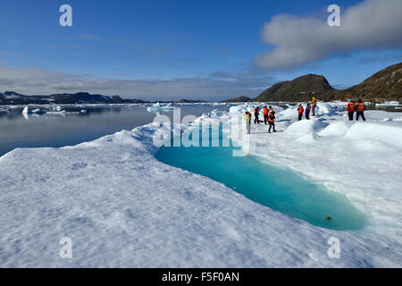 Groupe de personnes debout sur un banc de glace ou les glaces à la dérive, Tunu Fjord, l'Est du Groenland, Kalaallit Nunaat Banque D'Images