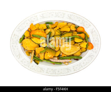 Vue de dessus de croustilles de légumes séchés sur un vieux plat de service ovale isolé sur un fond blanc. Banque D'Images