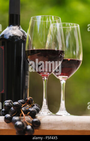 Deux verres à vin et une grappe de raisins en face d'une bouteille de vin Banque D'Images