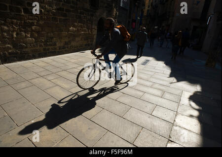 Man riding bicycle sur rue dans le vieux quartier de Barcelone Catalogne Espagne ES Banque D'Images