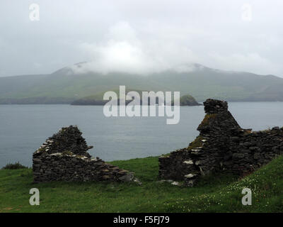 Ruines de l'habitation en pierre abandonnée sur une grande île Blasket, Irlande avec fond de l'océan Atlantique et Slea Head péninsule de Dingle Banque D'Images