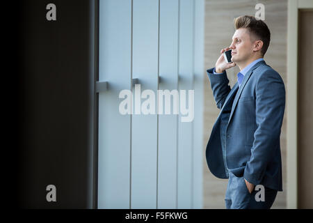 Cute business man dans un strict costume noir Banque D'Images