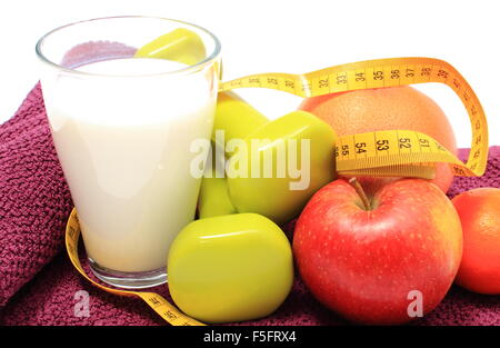 Fruits frais, ruban à mesurer, verre de lait et vert pour l'utilisation d'haltères dans fitness allongé sur une serviette mauve, concept minceur, Banque D'Images