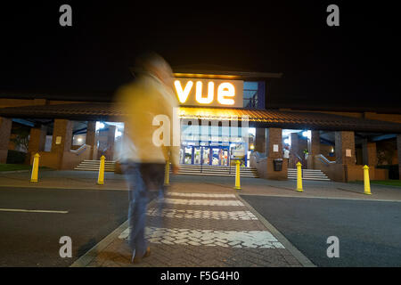 Homme marchant vers cinéma Vue par l'entrée de la nuit Banque D'Images