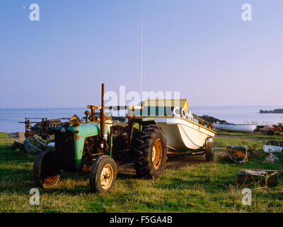 Bateau de pêche établis hors de la mer par de vieux tracteur et remorque, les PNCA, Bardsey Island, au nord du Pays de Galles, Royaume-Uni Banque D'Images